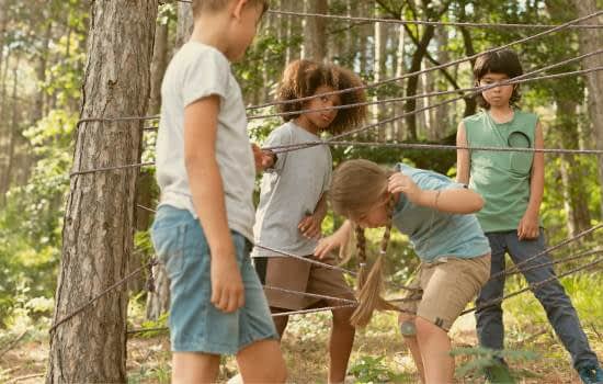 enfants jouant dans la foret au jeu de la toile d'araignée