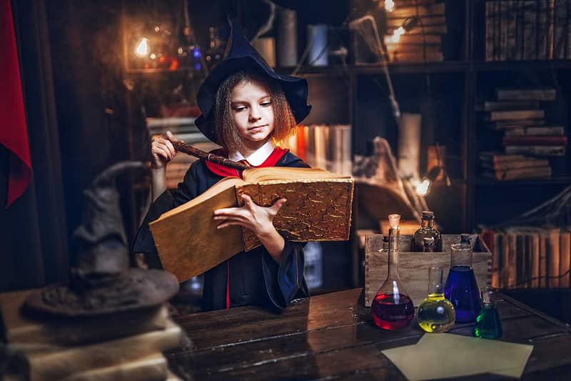 fille déguisée en sorciere avec un grimoire